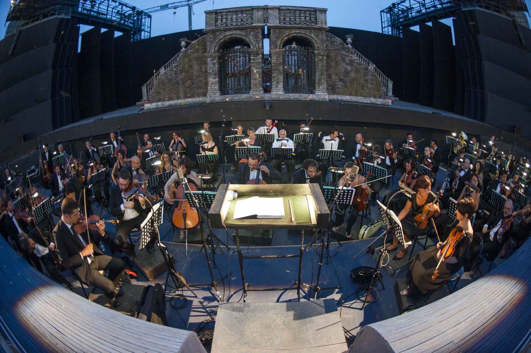 L’Orchestra del Festival Puccini sul palcoscenico all’aperto di Torre del Lago Puccini, ripresa dall’alto